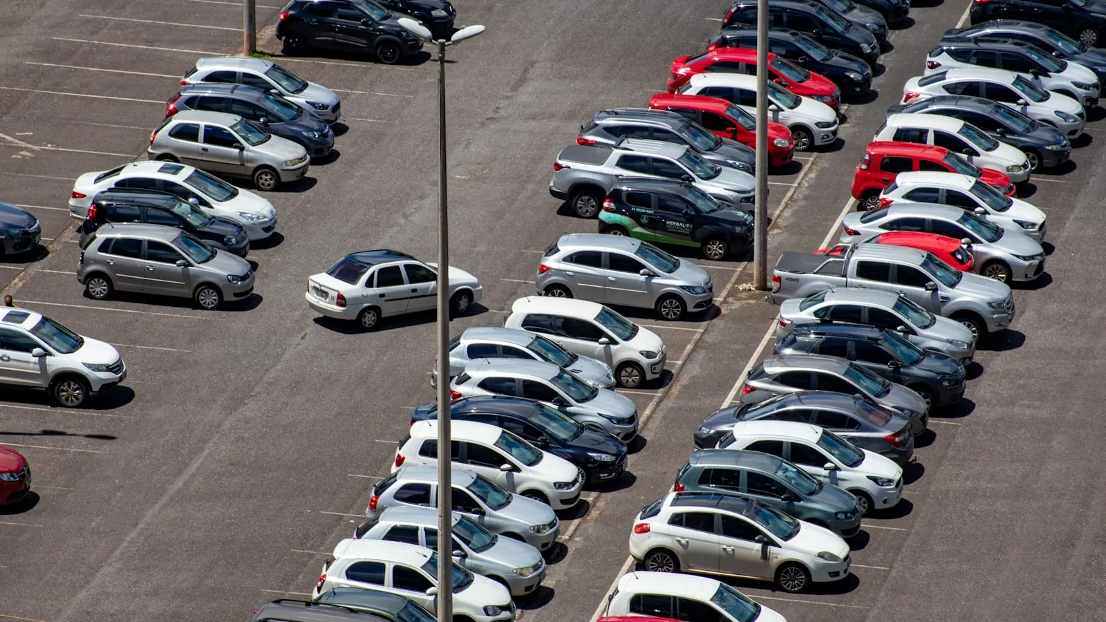 Parkplatz mit dicht stehenden Fahrzeugreihen von oben